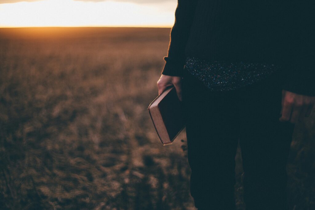 Pastor holding the Bible in a field.